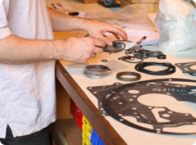Worker sorting Clark transmission parts and Dana transmission gaskets.